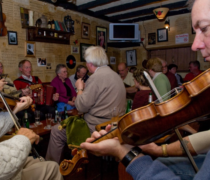 Traditional Irish music session in a packed Irish pub -fiddle,accordion and whistle