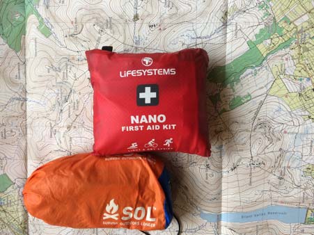 Lifesystems nano first aid kit and sol emergency bivvy bag sitting on a mourne mountain map