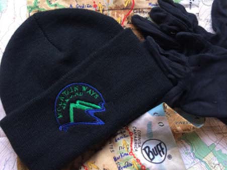 Mountain Ways Ireland logoed black beanie , gloves and buff on top on a map -Blog- What's in my rucksack?