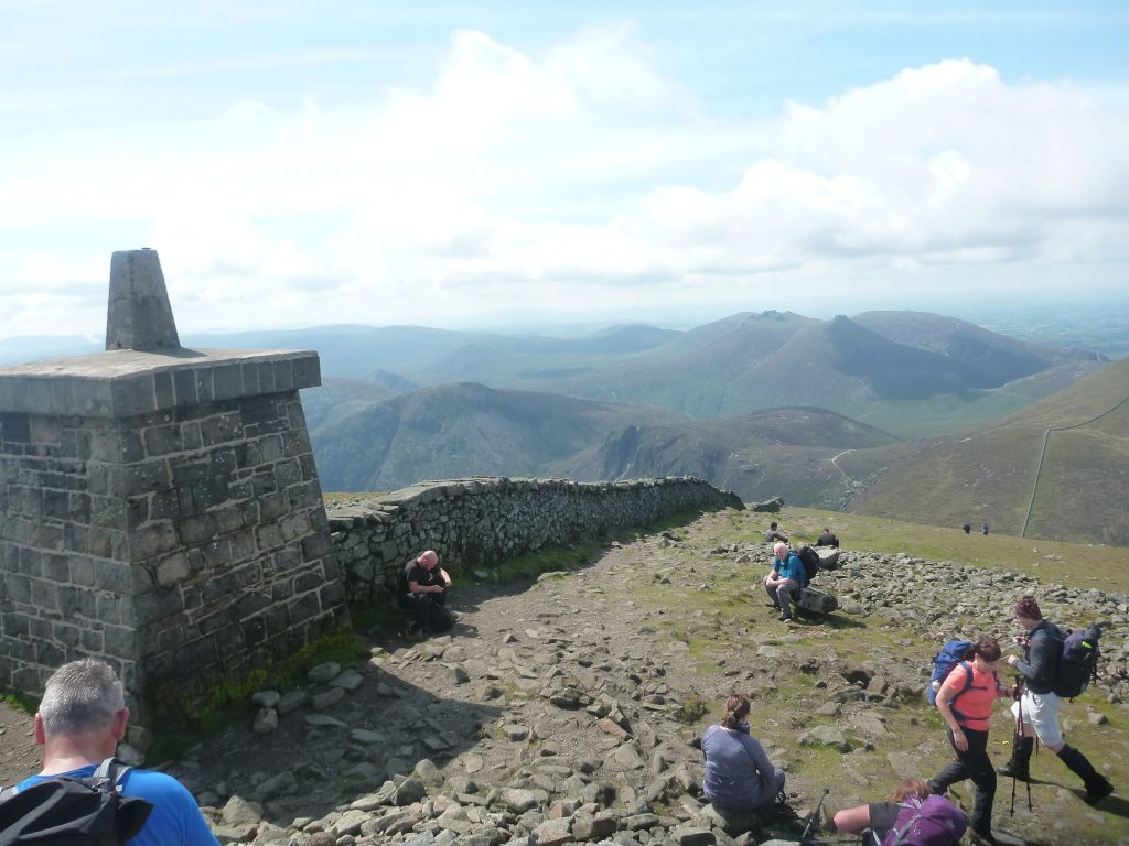 Hikers on summit of mountain on sunny day