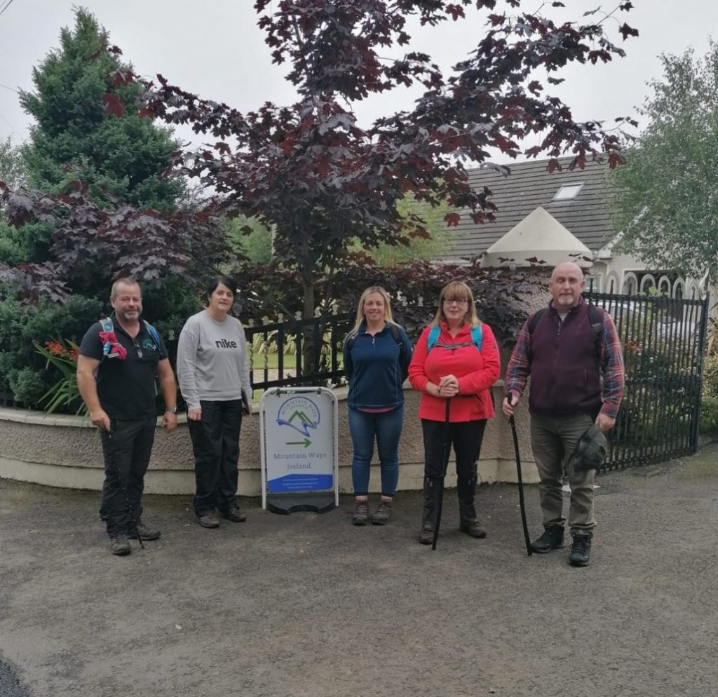 Tour Group at gate entrance with sign Mountain Ways Ireland